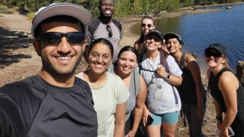 EPM students pictured on a hike in front of trees and a lake