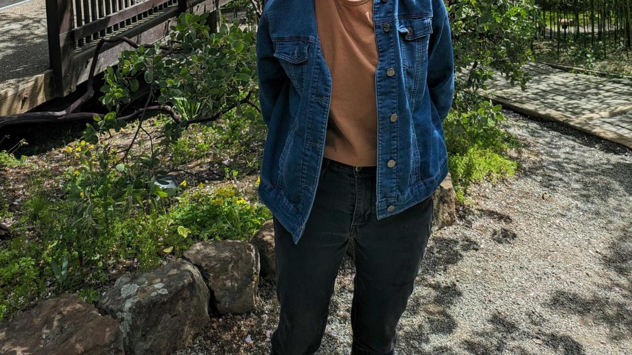 Alex Berk featured smiling in front of a tree.