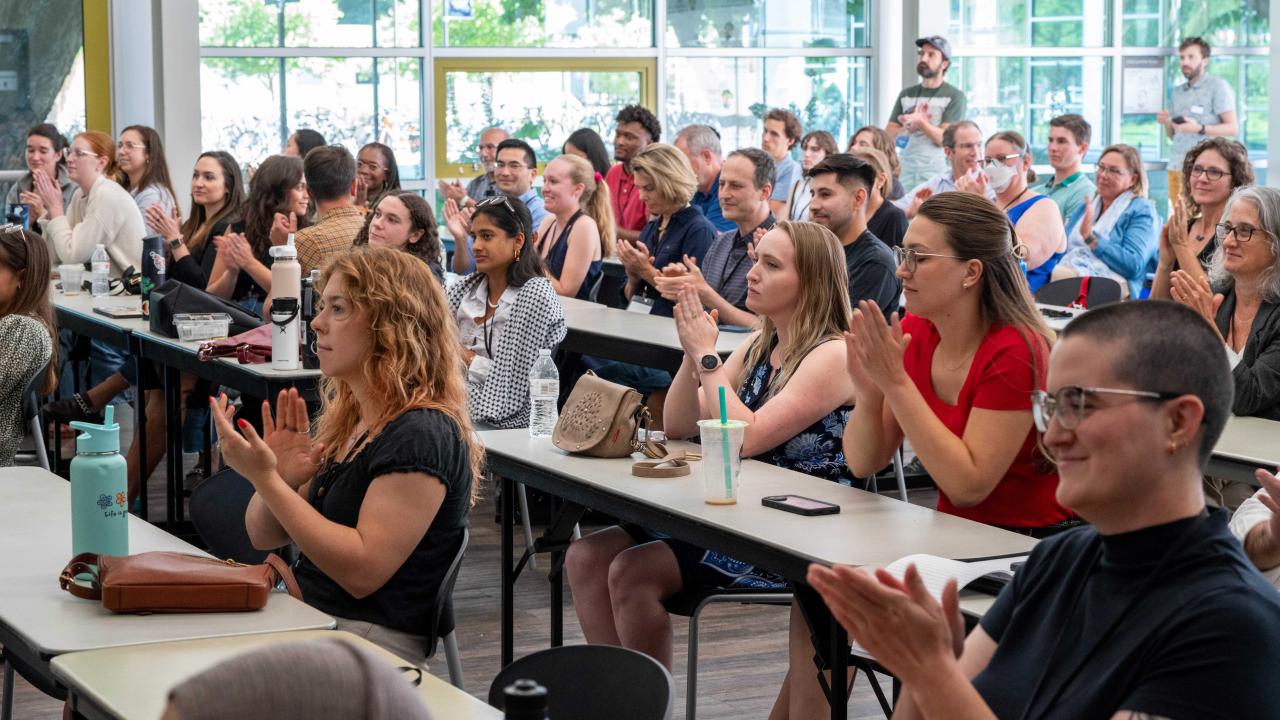 Attendees of the Policy Symposium featured clapping after a presentation concluded.