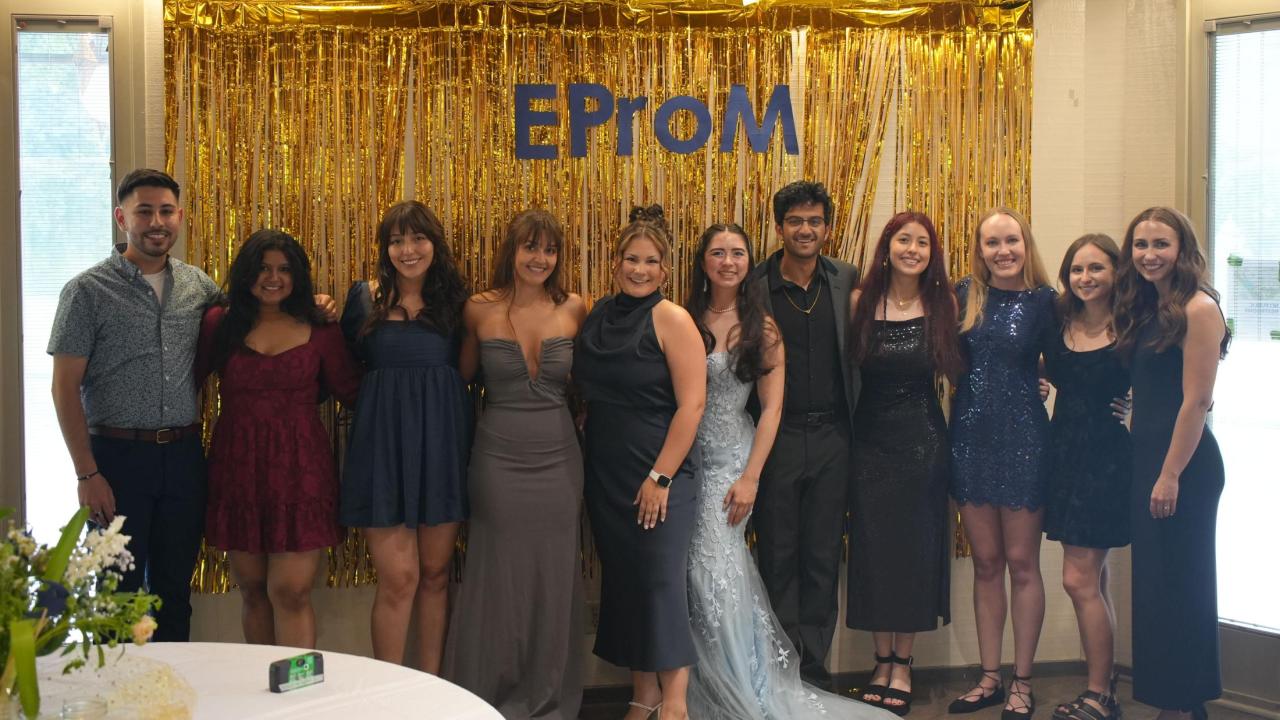 EPM social committee featured in front of a photo backdrop