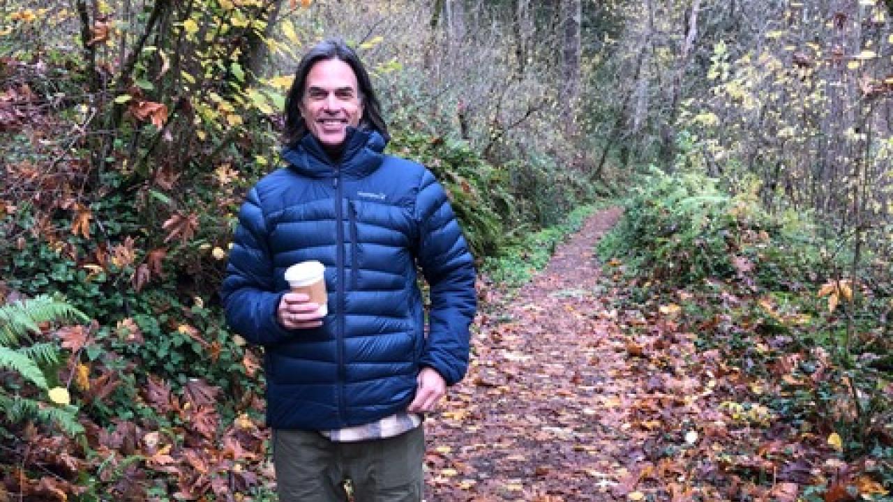 Eric Post standing on a wooded area.