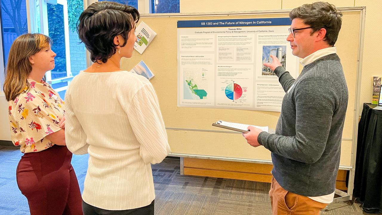 EPM Networking event- a student presents their poster to a group of professionals