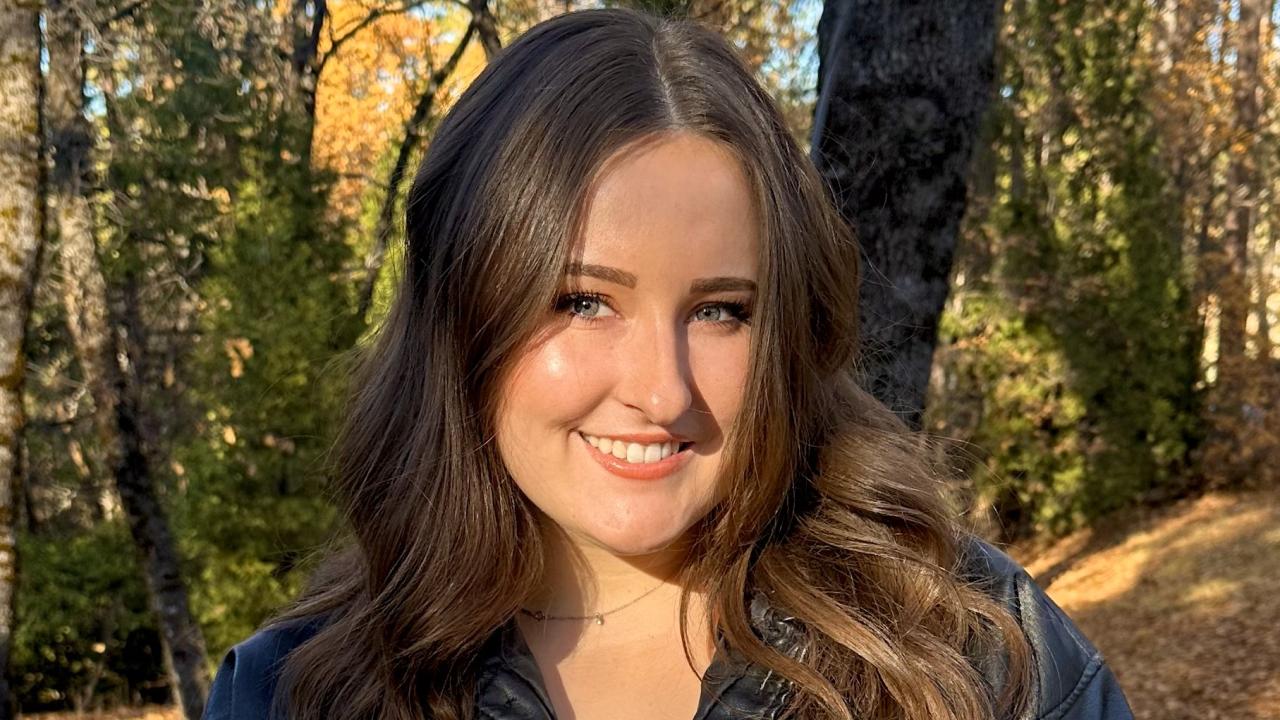 Madison Pelland in front of trees smiling.
