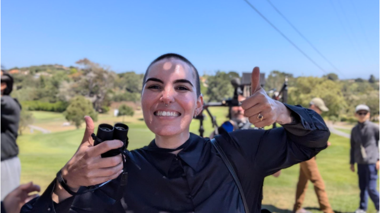 Erica Parker smiling with binoculars in her hand.