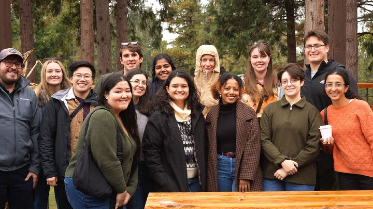 EPM students at Apple Hill, standing in front of trees and a wooden table.