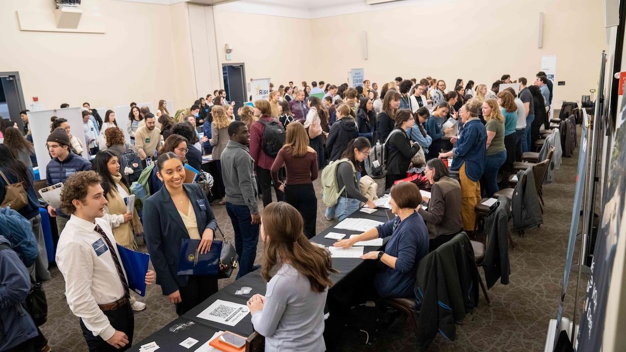 Job fair participants walking around the room.