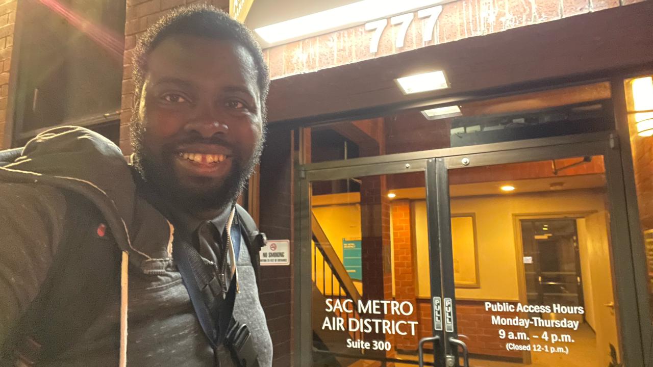 Joel Chima smiling outside Sac Metro Air Quality District building