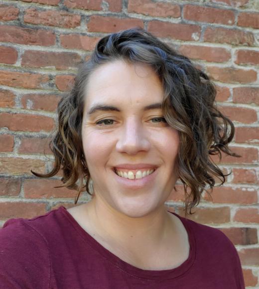 Melissa Harris featured smiling in front of a brick wall.