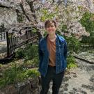 Alex Berk featured smiling in front of a tree.