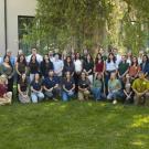 A group of new students standing in rows in front of a tree at Walker Hall.