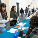 Two students are speaking with employees from Ascent Environmental. 