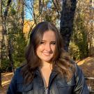 Madison Pelland in front of trees smiling.