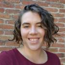 Melissa Harris featured smiling in front of a brick wall.