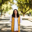 Morgan Hickey featured standing in front of trees and a stole for her graduation from UC Davis.