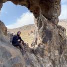 Daniel Harper sitting in a rock formation near Barstow, CA